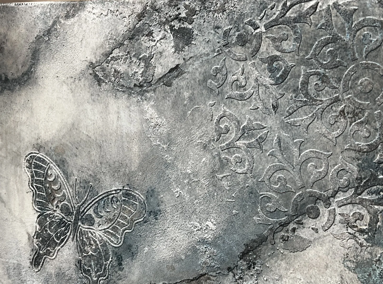 Butterfly and floral relief sculpted into silver-grey plaster