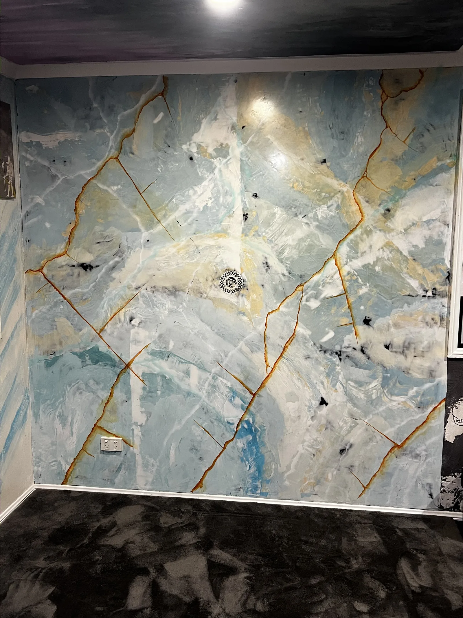 Blue and white marble-effect feature wall with copper and gold veining