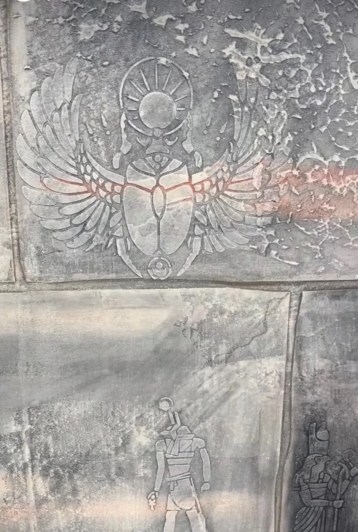 Hand-sculpted winged scarab relief raised out of a stone-block plaster finish