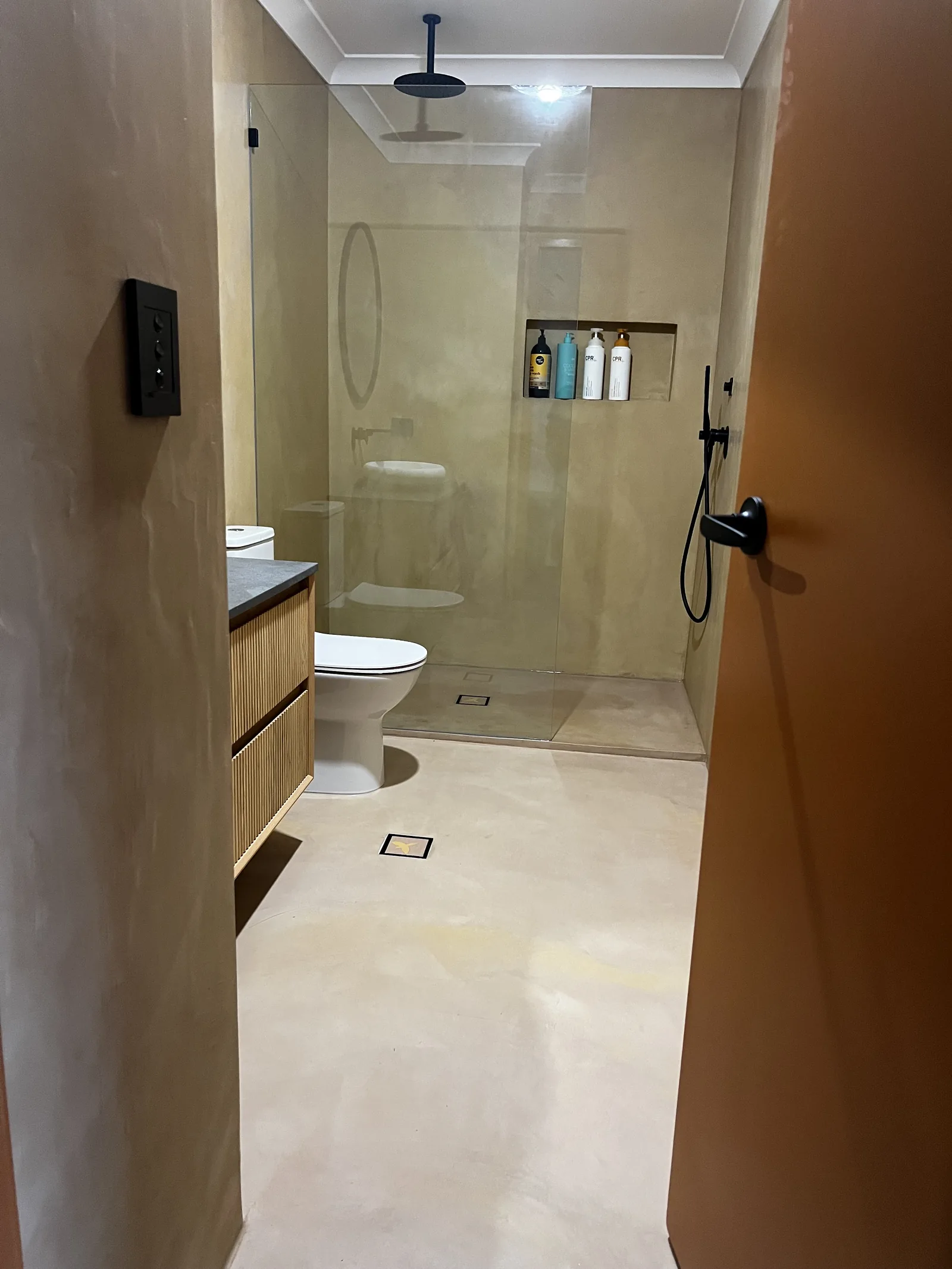 Seamless micro cement bathroom walls and floor with a walk-in shower