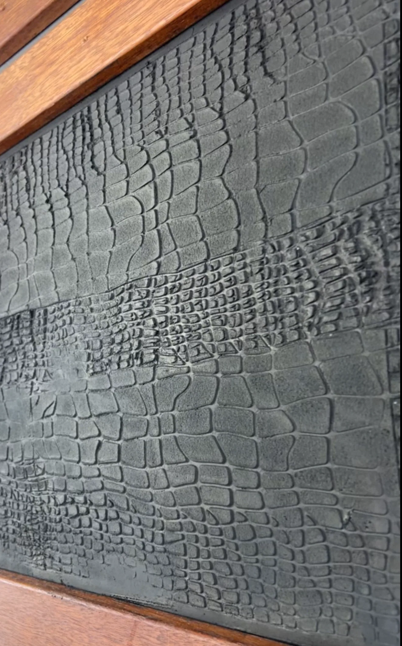 Crocodile-skin textured micro cement panel in a timber frame