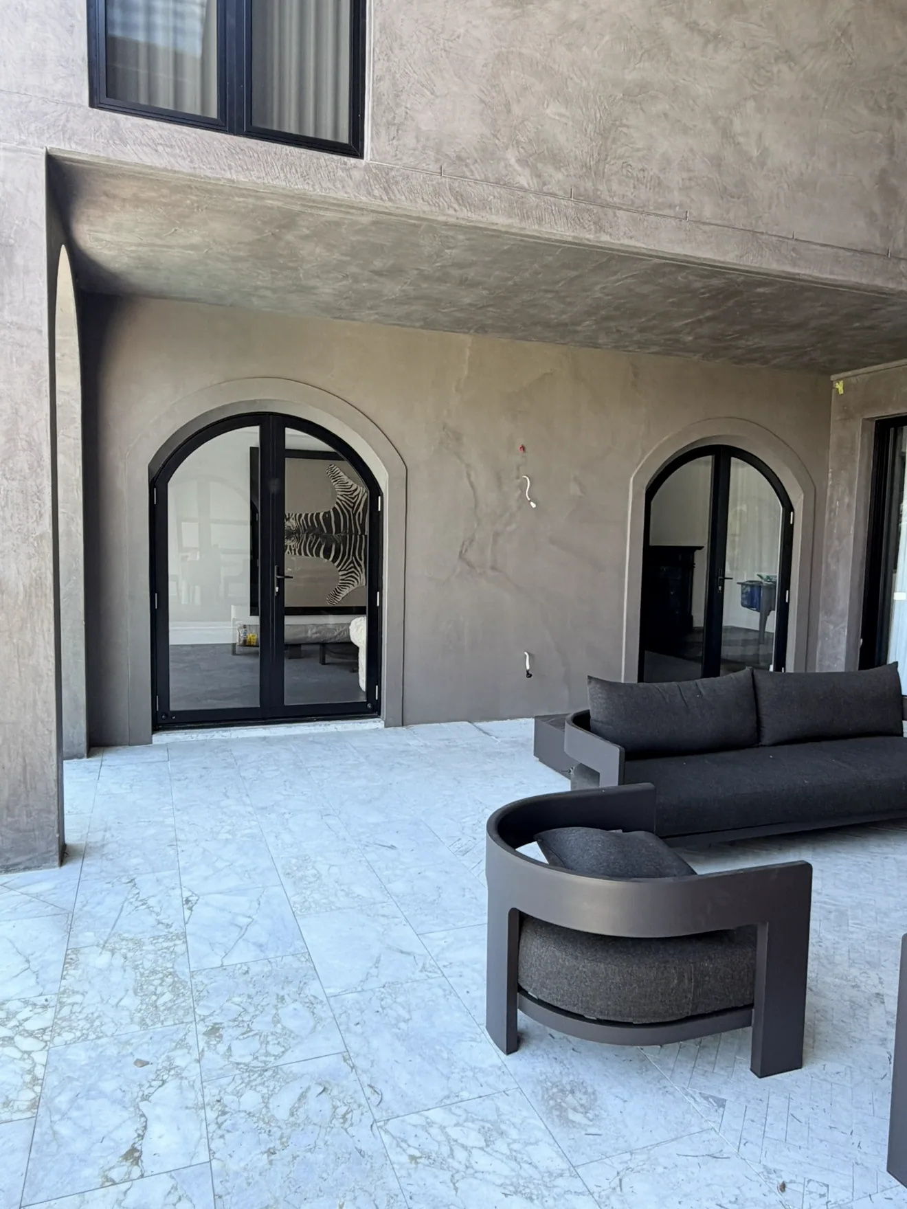 Outdoor entertaining area with micro cement walls and arched doorways
