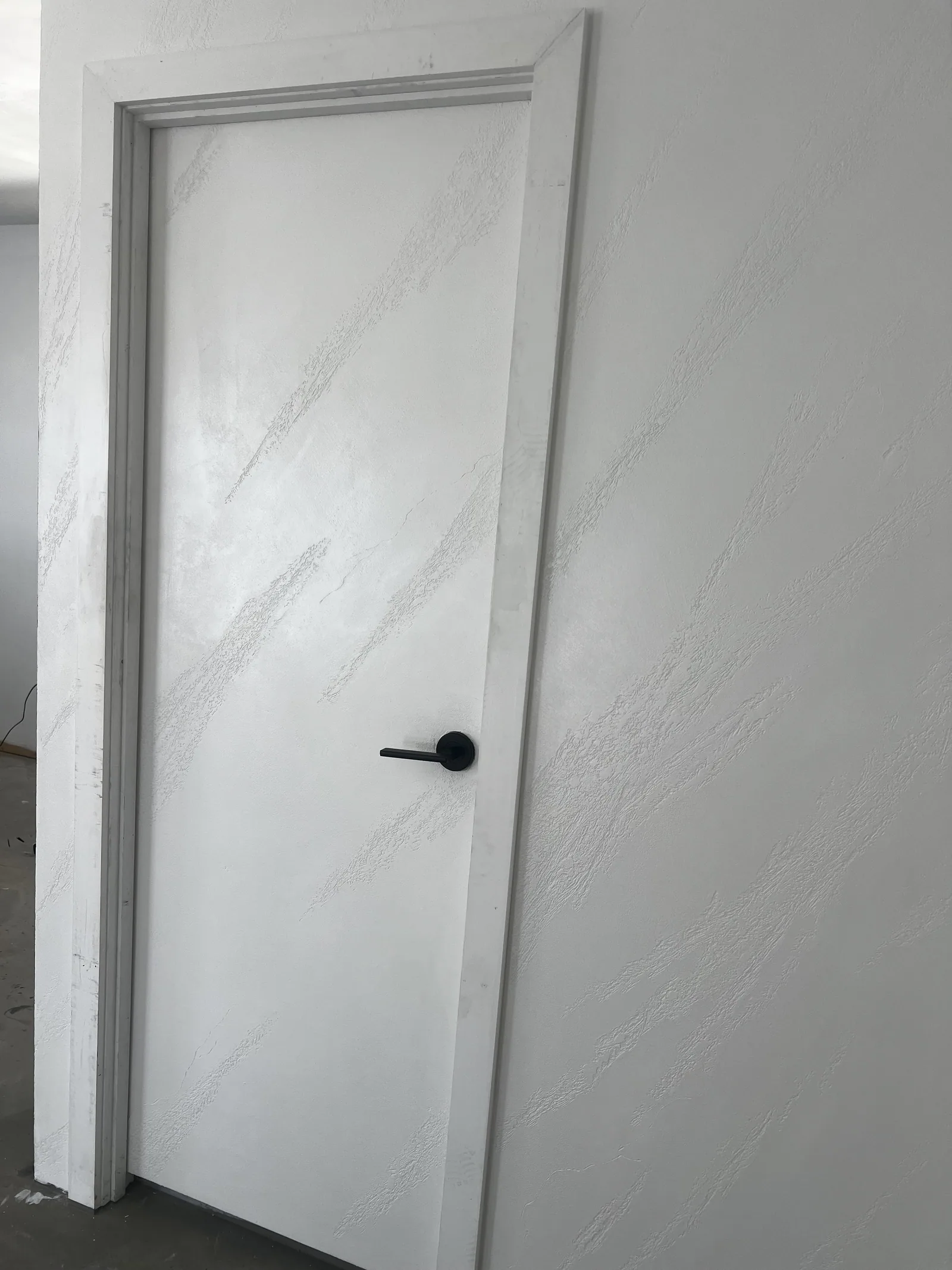 White split-stone finish carried across a bathroom entry door and its frame