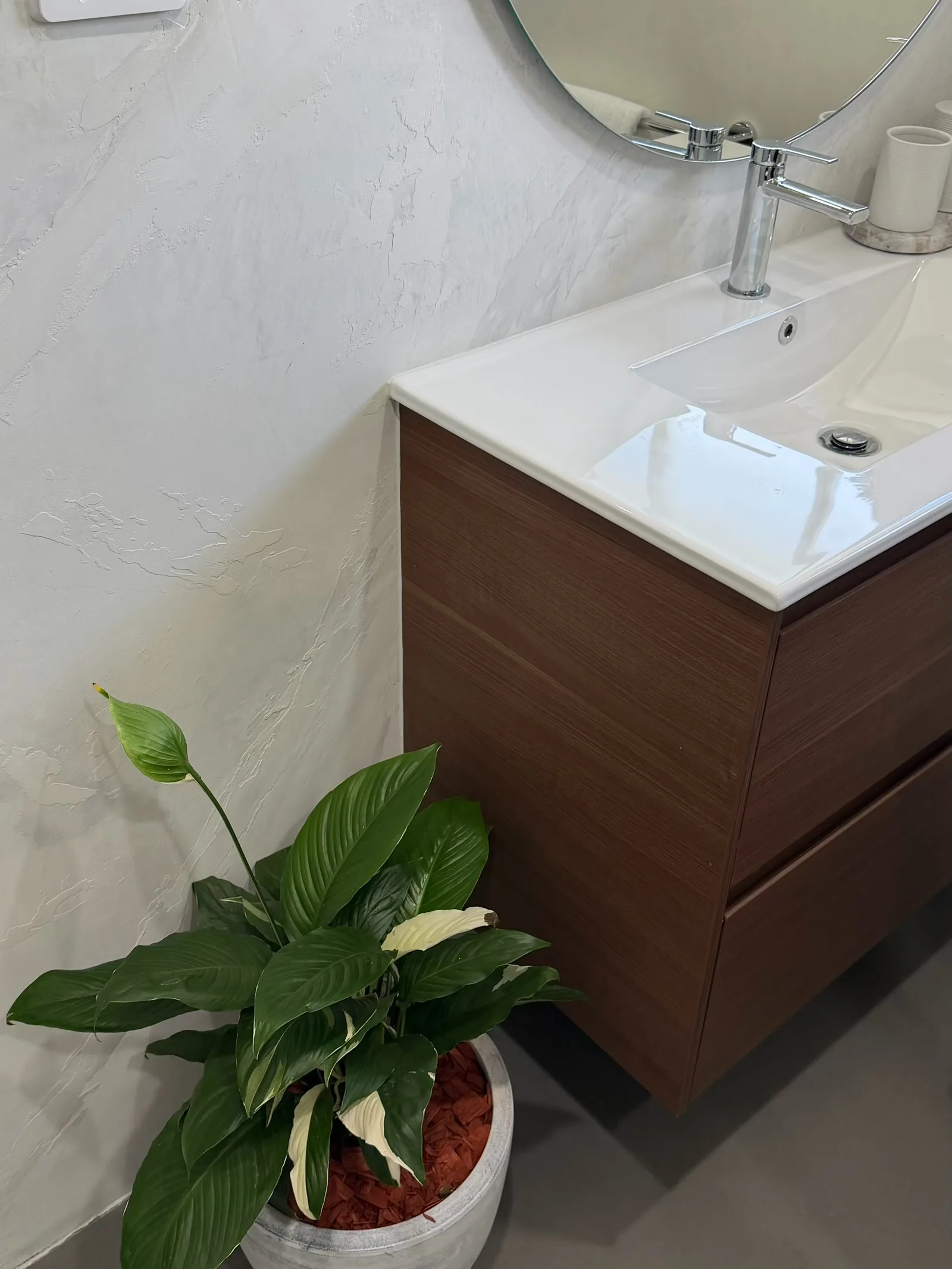 Off-white textured plaster wall beside a timber vanity
